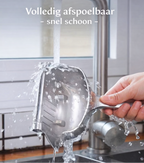 Person washing a metal colander under running water in a kitchen sink.